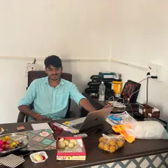A team member at his desk during the Bihar office opening, surrounded by sweets and festive items. It reflects the celebratory and positive atmosphere of our new beginning.