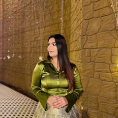 The olive green satin shirt brings a modern, jewel-toned feel to this traditional printed skirt, creating a balanced and eye-catching ensemble.