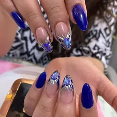 A stunning royal blue set with accent nails featuring intricate silver and crystal details.