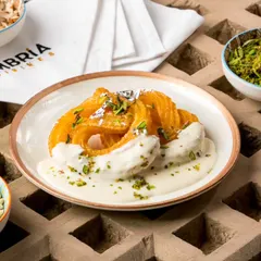 A dessert that perfectly captures our spirit of innovation. This is our signature Paneer Jalebi, served on a bed of rich, creamy rabri and garnished with pistachios. It's a unique sweet ending your guests will talk about for years.