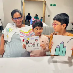 A mother and her children painting together at a baby shower, creating art for the new arrival.