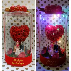 This romantic showpiece features a couple figurine under a heart-shaped tree, all enclosed in a glass dome with LED lights. It's a beautiful gift to celebrate Valentine's Day or an anniversary.