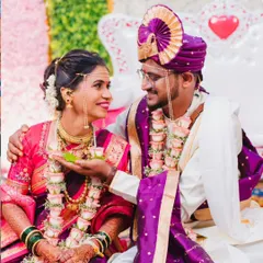 A tender moment during a Maharashtrian wedding, showcasing the beautiful bond between the couple. The groom's admiration and the bride's joyful expression are the focus of this candid shot.