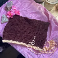 Here’s another version of my lace-up mini skirt, this time in a solid stitch. I made this one in a rich brown with a contrasting cream border and tie. You can see the handmade crochet texture and how the side detail works.