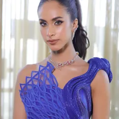 A front-facing shot of the model, where the tight, sleek ponytail emphasizes her sharp features and the dramatic eye makeup.