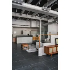 The reception area sets the tone for the showroom. We kept the color palette neutral with raw concrete and dark stone flooring, allowing the finely crafted furniture to take center stage.