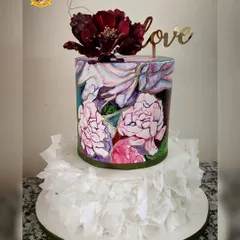 Art meets cake in this unique wedding design. The bottom tier features delicate, hand-applied wafer paper ruffles, while the top tier is hand-painted with a beautiful floral watercolor design. A single, dramatic sugar flower and a "love" topper complete this artistic statement piece.