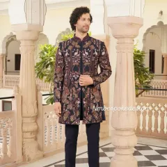 This navy blue indowestern sherwani is covered in detailed, multi-colored threadwork that creates a rich tapestry of birds and foliage. It's a bold and artistic choice for a groom's main wedding event or reception.