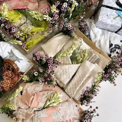 An overhead view of a trousseau collection decorated with exotic fresh flowers. We use fragrant tuberoses and delicate purple daisies to create a lush, garden-like feel around each gift tray, adding a touch of natural elegance.