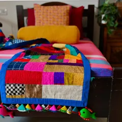 A closer look at the quilt's patchwork surface. Each square is a remnant from a past project, a piece of silk, cotton, or hemp that was too precious to throw away.