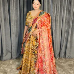 A full-length shot of the bride in her vibrant, multi-coloured lehenga, showing how the hair, makeup, and outfit come together.
