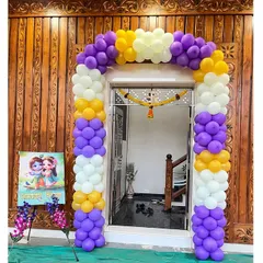 An entrance balloon arch for a Krishna-themed party. The purple, yellow, and white balloons welcome guests to the celebration.