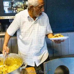 A host serving food to our team. The hospitality we receive at local clubs across the UK is always exceptional.