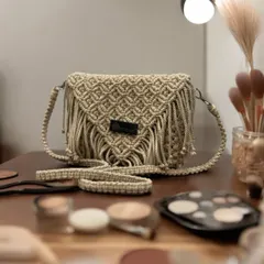 This beige fringed sling bag is a classic. It's pictured here with some makeup essentials, showing how it's the perfect little bag for your daily adventures.