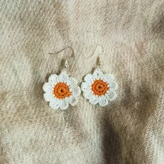 Simple and sweet, these little daisy earrings are perfect for everyday wear. The white petals and orange center are crocheted from soft cotton thread.