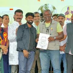 A happy moment presenting a sketch to director and producer T.S. Nagabharana. His smile shows the simple joy that a piece of art can bring.