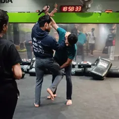 This is a knife defense drill in action. The focus is on simultaneous block and counter. As one student attacks, the other practices controlling the weapon arm while delivering a disabling knee strike to the groin. This is how you train for survival.