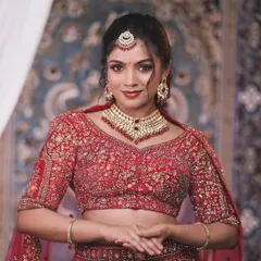 A beautiful portrait of a model wearing a delicate Kundan choker with red stones. This piece is perfect for adding a touch of elegance to a reception or pre-wedding event.
