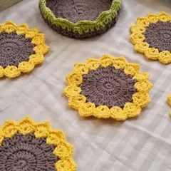 A top-down view of our sunflower coasters and the matching basket. You can see the detailed stitch work that goes into each piece.