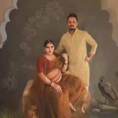A portrait that reflects culture and timelessness, featuring a couple in a setting reminiscent of Indian royal art. The scene, complete with a peacock and architectural arch, is carefully styled to create a unique and personal piece of concept maternity art.