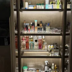 A full view of a beautifully organized beauty cabinet. With tiered shelves and clear trays, every product from skincare to fragrance has its own place, creating a functional and aesthetically pleasing display.