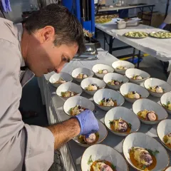 Co-founder Chris meticulously plating a course for a sustainable farm-to-table dinner. Every detail matters when creating a multi-course meal, ensuring each plate is a work of art.