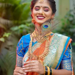 This portrait captures a moment of serene bliss. With her eyes closed and a gentle smile, the bride looks completely at peace. The peacock feather adds a soft, delicate touch to this beautiful bridal shot.