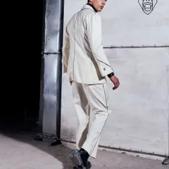 The back view of the Ivory Industrial suit, showing the clean lines and contrast piping that define its structure. This is a suit built for making an entrance and an exit.