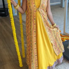 This lightweight yellow jacket gown is a perfect outfit for a Haldi ceremony or as a wedding guest. The printed jacket adds a traditional touch to the modern silhouette.