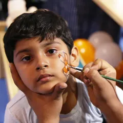 Face painting is always a huge hit at our parties. Here, a child gets a custom design, adding a touch of creative fun to our anniversary celebration.