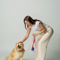 A happy dog makes for the best photos. In this lifestyle shot for Luxolandshop, a model gives a gentle pat to a smiling dog wearing one of their colorful harnesses. This kind of image creates a positive and warm feeling for the brand.