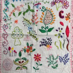 A beautiful freestyle sampler created by one of my students. After learning various stitches, she planned and executed this project, filling the fabric with colorful flowers, leaves, and a central paisley motif.