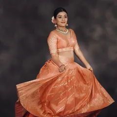 The flowing fabric of the peach lehenga makes it perfect for capturing beautiful, twirling shots during a photoshoot.