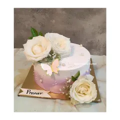 This cake combines a soft purple ombre effect with the elegance of fresh white roses. A single butterfly accent adds a touch of whimsy to this beautiful and minimalist design.