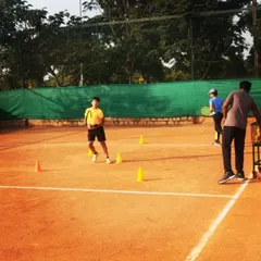 A young student navigates a cone drill, learning proper footwork and court positioning. These exercises are fundamental for developing movement skills.