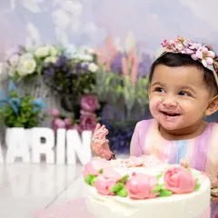 The best part of turning one is getting to eat the cake! This adorable shot captures the sweet, messy joy of a first taste of birthday cake during a floral-themed smash session.