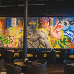A different angle of the Lil Gamby mural, showing how the artwork wraps around the seating area. The goal was to make the art a core part of the dining experience.