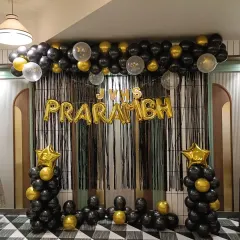 For the "PRARAMBH" launch event, I created this bold black and gold theme. The setup includes a black fringe curtain, foil letter balloons for the event name, and matching balloon pillars for a grand statement.