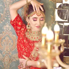 This is a classic reception look, perfect for a bride who wants something bold and elegant. The focus is on the advanced eye makeup, with a soft cut crease and pink tones, paired with a stunning red lehenga and matching jewellery.