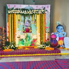 For a Janmashtami celebration, I created this traditional backdrop featuring Lord Krishna. The decor includes marigold garlands, cow and calf cutouts, and a decorated swing for the deity.
