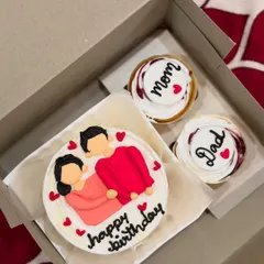 A birthday combo for a parent, with a bento cake featuring a cute illustration and two cupcakes dedicated to "Mom" and "Dad".