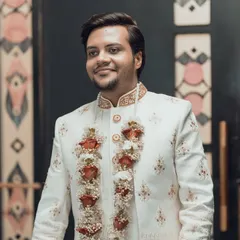 A handsome portrait of a groom in his elegant white sherwani, looking sharp and ready for his big day.