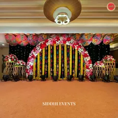 We designed this spectacular stage for a vibrant Haldi ceremony. A canopy of colorful Rajasthani umbrellas and a dramatic black backdrop make the floral arch and hanging marigold garlands pop, creating a truly grand and festive focal point for the event.