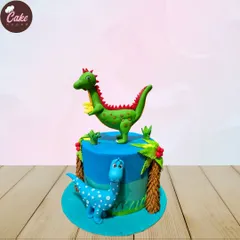 A fun and colorful dinosaur-themed cake. This design features two friendly, hand-sculpted dinosaurs in a prehistoric setting with edible palm trees.