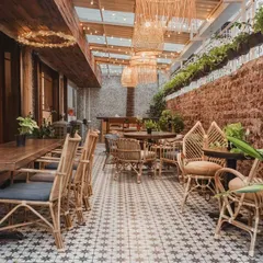 I love how the light filters through our covered patio. The combination of exposed brick, woven lamps, and plentiful plants creates a warm and inviting atmosphere, day or night.