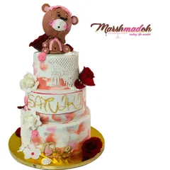 This grand 3-tier, 6kg Belgian Chocolate cake was designed for a first birthday. It features a watercolour buttercream finish, edible lace, handmade flowers, and a cute, hand-sculpted teddy bear topper.
