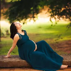 Soaking in a quiet moment of joy. Outdoor maternity sessions like this one use the beauty of nature and golden hour light to create a serene and timeless portrait of your pregnancy glow.