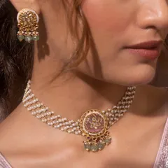 This rice pearl moti choker enhances your elegance with a fusion touch. The multi-strand pearl choker is centered with a pink stone pendant featuring Kundan work, perfectly blending tradition with contemporary style as seen on the model.