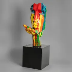 A modern take on classical art, this sculpture features a face with a hand blowing a kiss, all covered in a vibrant, multi-colored paint drip. It's a bold and expressive piece for a contemporary art lover.