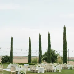 The elegant reception setup at a California vineyard estate. The clean white decor and string lights create a magical ambiance against the rolling hills.